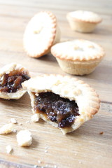 Selection of several mince pies, some broken open or partly eaten. A traditional festive Christmas dessert or pudding. Copy space for text.