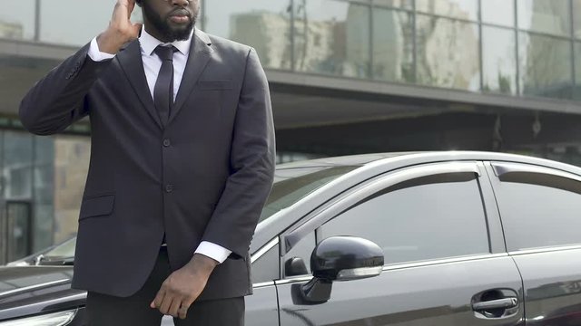Serious bodyguard of official carefully examining situation, looking around
