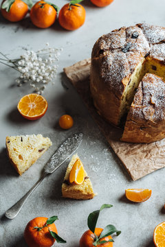 Panettone, traditional Italian Christmas cake. Close-up with slice and oranges.