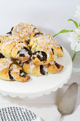 Poppy seeds croisssants. Traditional, polish croissants. White background, white wooden table and white plates.
