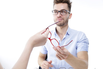 Młody mężczyzna przymierza okulary  © doroguzenda