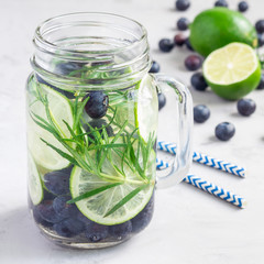 Healthy cold infused water with fresh blueberry, lime and rosemary, square format