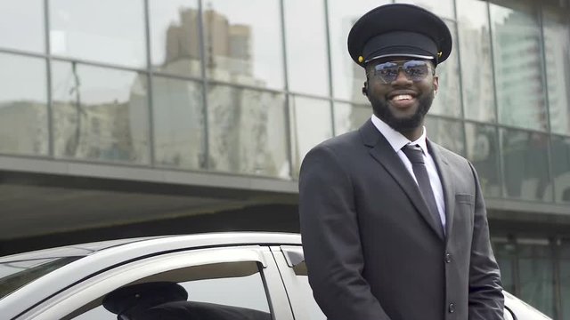 Personal driver giving passers-by sincere smile waiting for boss from airport