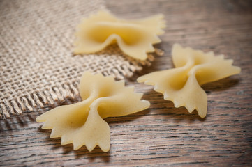 pâtes en forme de papillon et toile de jutte sur table en bois