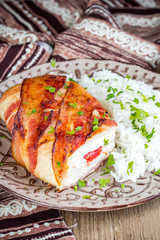 Chicken wrapped in bacon stuffed with soft cheese with rice, tasty homemade dish, beautiful food