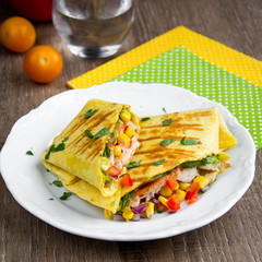 Mexican burritos with tortilla, chicken, corn, tomatoes, onion, spicy traditional dish, tasty food