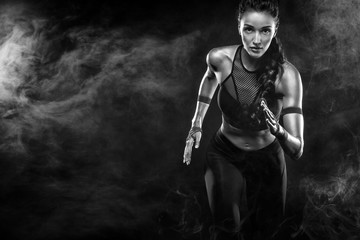 Fototapeta na wymiar A strong athletic, woman sprinter, running on black background wearing in the sportswear, fitness and sport motivation. Runner concept with copy space.