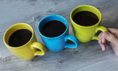 a three cup different color on the wooden gray background