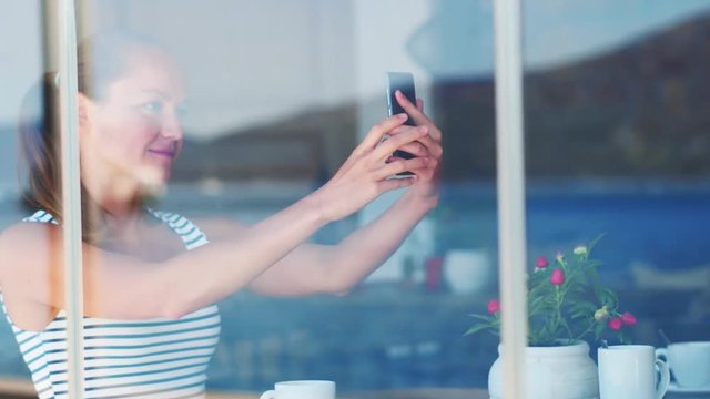 smiling young woman maiking selfie in cafe shop