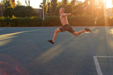 A man athlete starts to run, jumps in the stadium