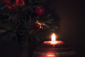 Christmas candle and small Christmas tree in the dark.