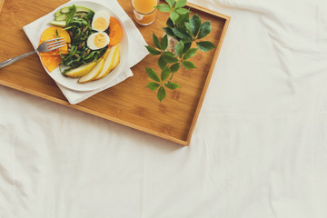 Healthy eating concept. Woman having breakfast in bed. Top view.