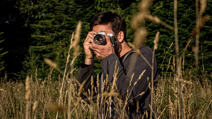 Passionate Photographer in nature making his shot in the warm light of the evening sun.