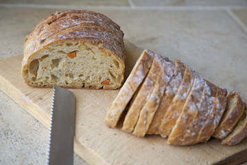 Slicing a Loaf of Bread on a wooden board