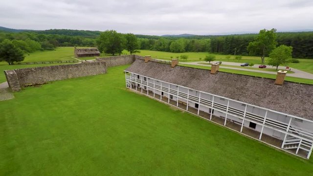 Aerial of the Calvert Arms/King&rsquo;s Colors flag waving in the breeze with the barracks in the distance at Fort Frederick in Maryland.