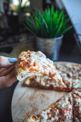 A piece of cooked pizza in a woman´s hand