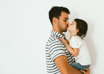 Side view portrait of handsome father kissing his little daughter. Young dad is enjoying time with his child. Handsome father with little girl. Happy father and daughter. Lifestyle family.