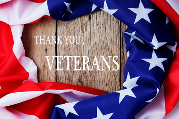 text thank you veterans and american flags on old wood background.