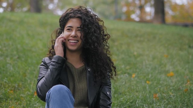 girl with curly hair talking on the phone