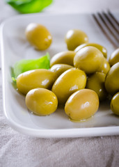 Green olives on a white plate