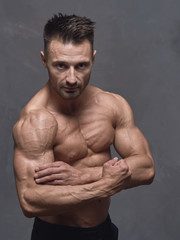 Obraz premium A physically strong man in black trousers and a naked torso.