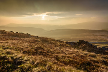 Beautiful autumn scenery in the Peak District - sun setting over Macclesfield road, scenic valley in the distance with dramatic storm clouds 