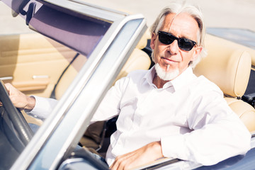 Senior Man Driving A Convertible Classic Car