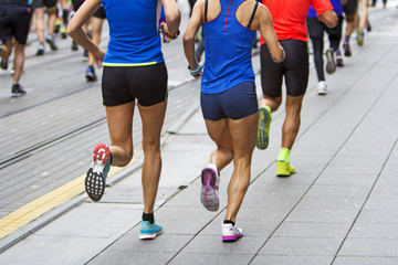 Marathon runners race in city streets, blurred motion