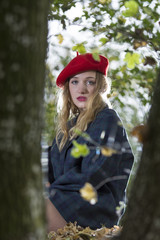 Young woman looking happy in forest in an autumn day