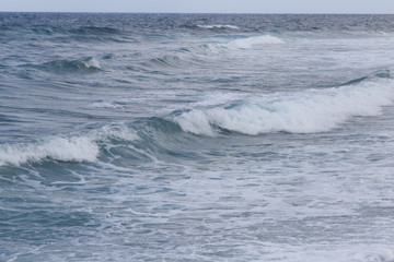 Deep blue and white ocean waves with horizon