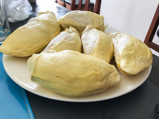 King of fruit delicious., Durian yellow meat on white plate on the wooden table.