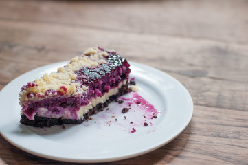 Popular bakery dessert blueberry cheese pie in white plate on classic wooden table.