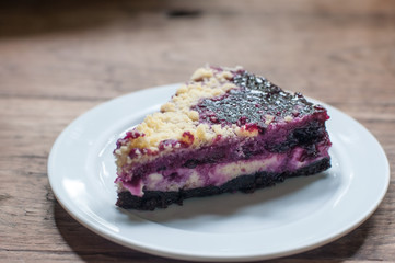 Popular bakery dessert blueberry cheese pie in white plate on classic wooden table.