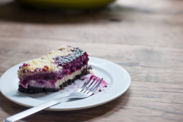 Popular bakery dessert blueberry cheese pie in white plate on classic wooden table.