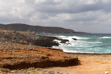 Seashore cloudy dirt road landscape with hills and mountains in Greece