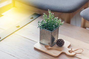 Flower pot and wooden tray lay on table, interior shop design.