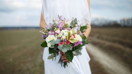 Beautiful bride with a bouquet. Bouquet in bride's hands. Soft focus