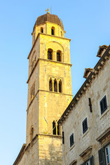 Fototapeta na wymiar The bell tower of the Franciscan church and monastery in the main city street Stradun in Dubrovnik, Croatia.