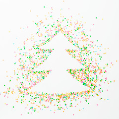 Christmas tree made of colorful bright confetti on white background. Flat lay, top view copy space