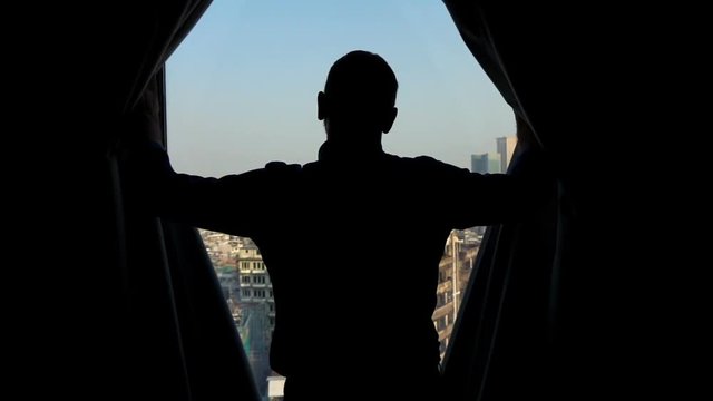 Silhouette of man unveil curtains and admire view from window, super slow motion 240fps
