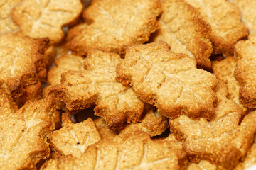 Closeup heap of homemade crunchy cookies in the form of leaves. Shallow focus. Food background.