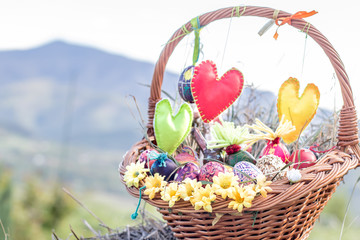Happy easter handmade colorful eggs basket grass chamomile daisies meadow straw outside