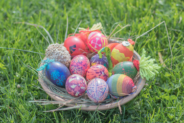 Happy easter modern colorful eggs handmade pottery plate grass chamomile daisies meadow outside