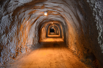 An old illuminated underground tunnel stretching into the darkness.