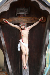 wooden statue depicting crucified Jesus and the INRI writings on