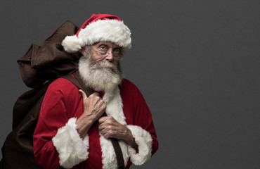 Santa Claus carrying Christmas gifts