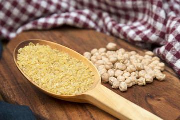 Spoon Filled With Cracked Wheat, Chickpeas At The Background