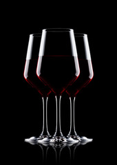 Glasses of red wine on black with reflection
