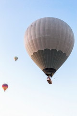 Many unrecognizable colorful hot air balloons against blue sky