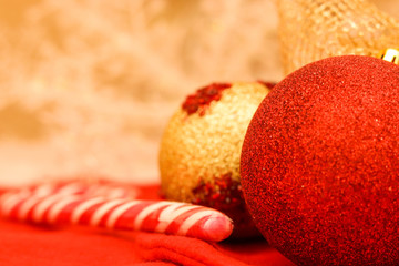 gold and red christmas balls with sugar stick and fire light